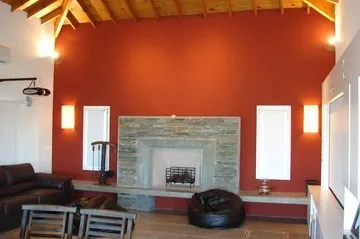 Hogar revestido en piedra laja y banco de cemento alisado